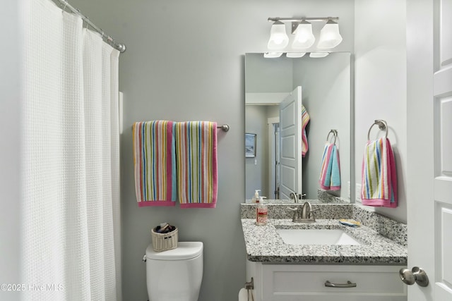 bathroom featuring a shower with curtain, vanity, and toilet