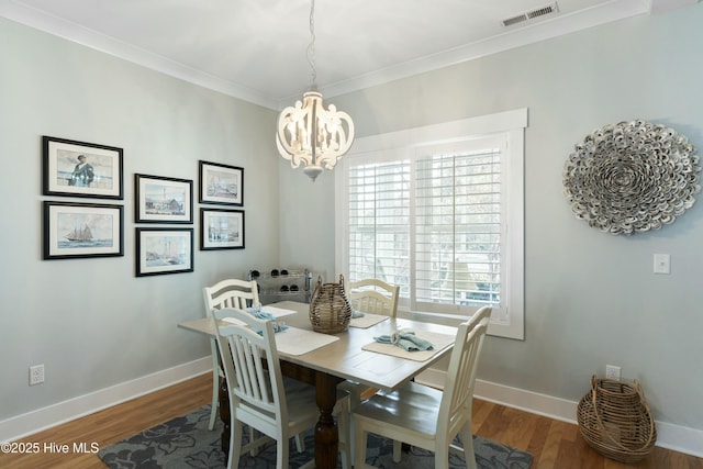 dining space with dark hardwood / wood-style floors and an inviting chandelier