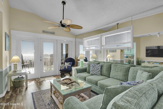 living room featuring french doors, a textured ceiling, vaulted ceiling, ceiling fan, and hardwood / wood-style floors