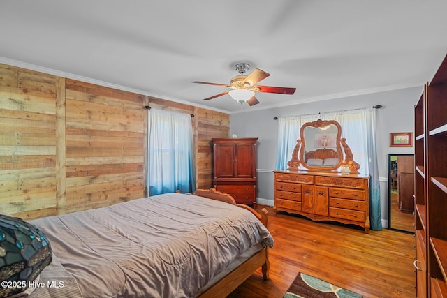 bedroom featuring ceiling fan, ornamental molding, and multiple windows