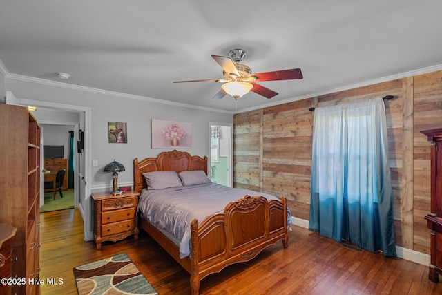 bedroom featuring ceiling fan, crown molding, dark hardwood / wood-style floors, and wooden walls