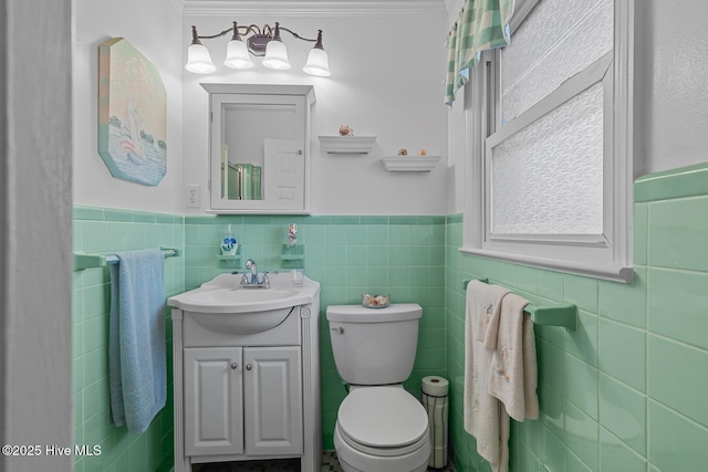 bathroom featuring vanity, ornamental molding, tile walls, and toilet