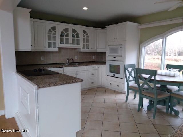 kitchen featuring white cabinetry, sink, and white appliances