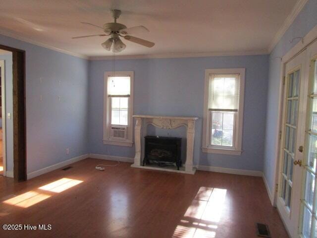 unfurnished living room featuring wood finished floors, visible vents, crown molding, and a premium fireplace