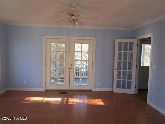 empty room with ornamental molding, french doors, and baseboards