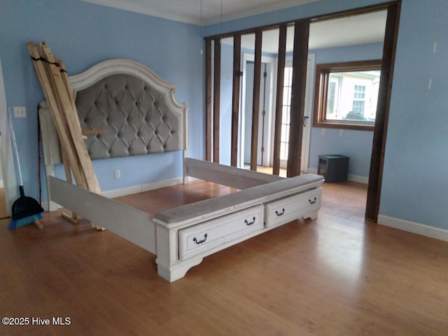 bedroom featuring crown molding and light wood-type flooring