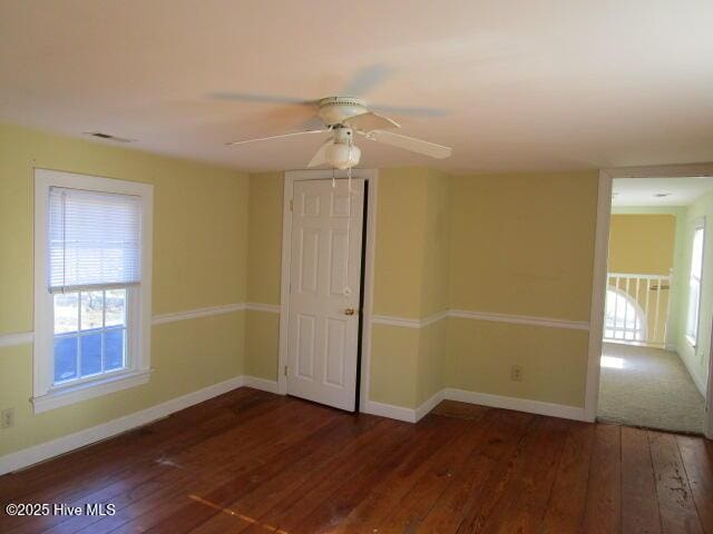 empty room with ceiling fan, hardwood / wood-style floors, and baseboards