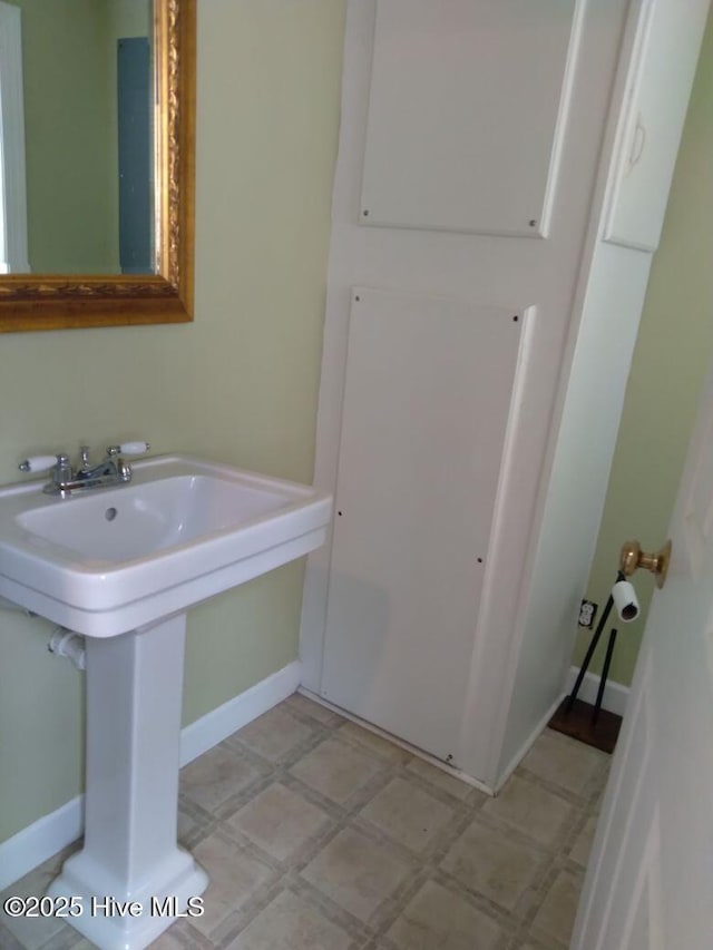 bathroom with a sink, baseboards, and tile patterned floors