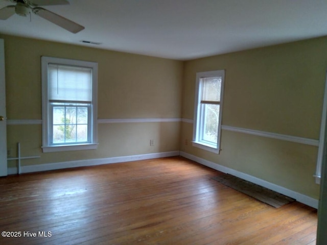 spare room with plenty of natural light, ceiling fan, and light hardwood / wood-style flooring