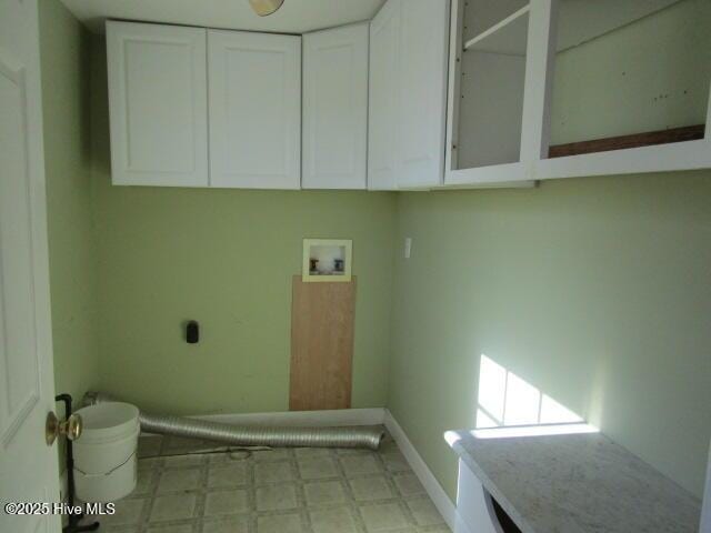 laundry room with hookup for a washing machine, baseboards, cabinet space, light floors, and electric dryer hookup