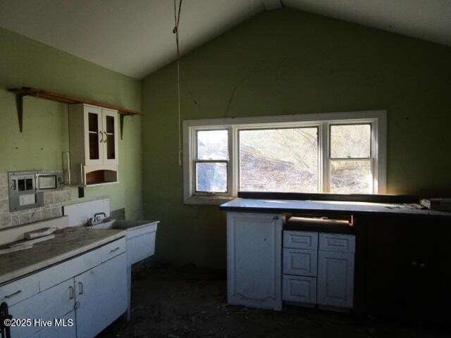 kitchen with lofted ceiling and white cabinetry