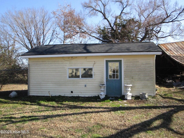 back of property with a yard and an outdoor structure