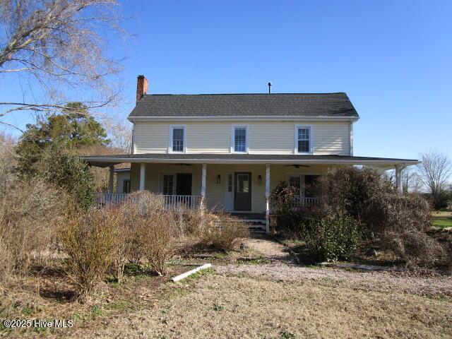 country-style home with a porch and a chimney