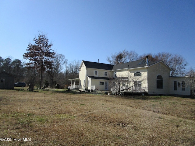 back of house featuring a lawn