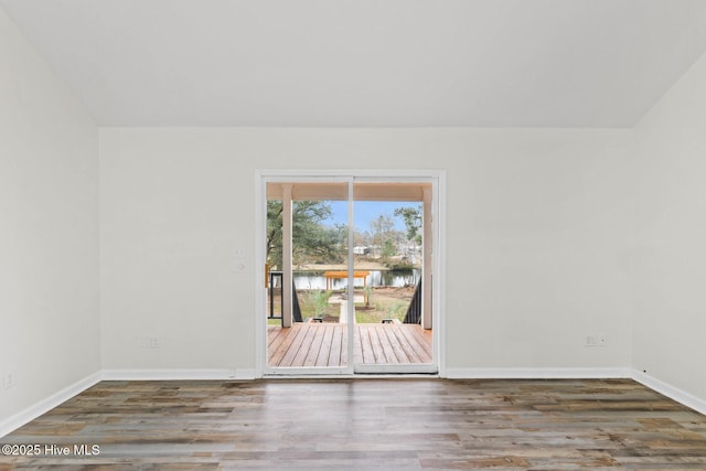 empty room featuring dark hardwood / wood-style floors and a water view