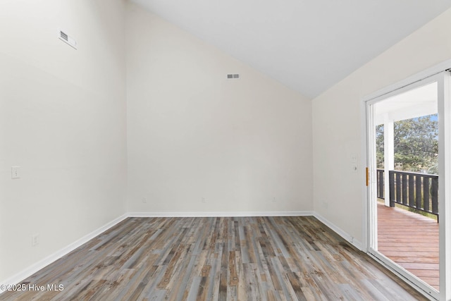 empty room with hardwood / wood-style floors and lofted ceiling