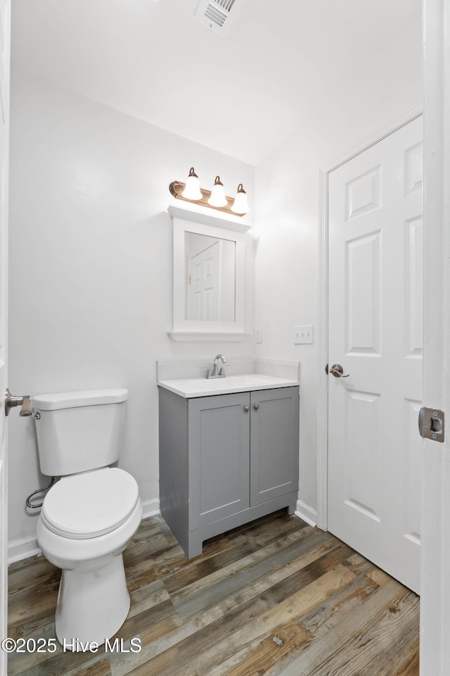 bathroom featuring vanity, toilet, and wood-type flooring