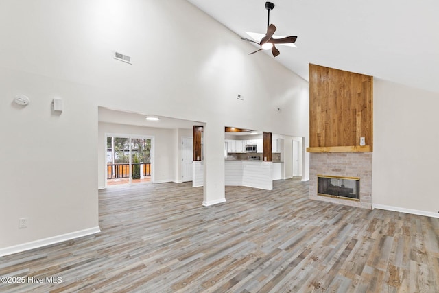 unfurnished living room featuring ceiling fan, high vaulted ceiling, and light hardwood / wood-style floors