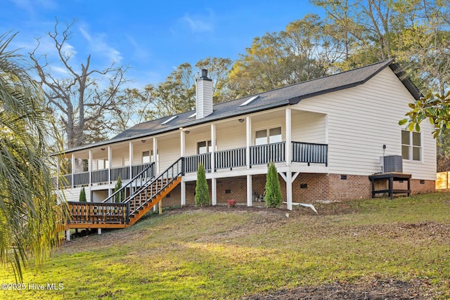 rear view of house with covered porch and a yard