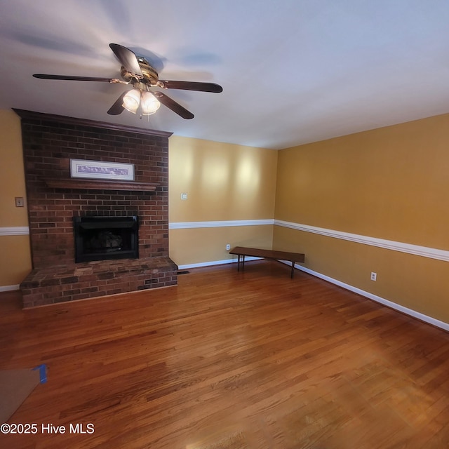 unfurnished living room with ceiling fan, hardwood / wood-style floors, and a fireplace