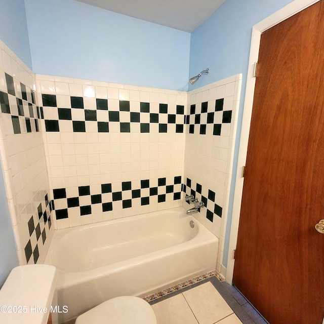 bathroom featuring tile patterned flooring, tub / shower combination, and toilet