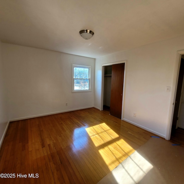 unfurnished bedroom with light wood-type flooring and a closet