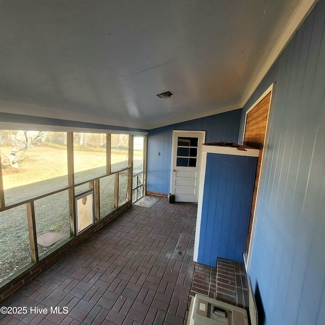 unfurnished sunroom featuring vaulted ceiling