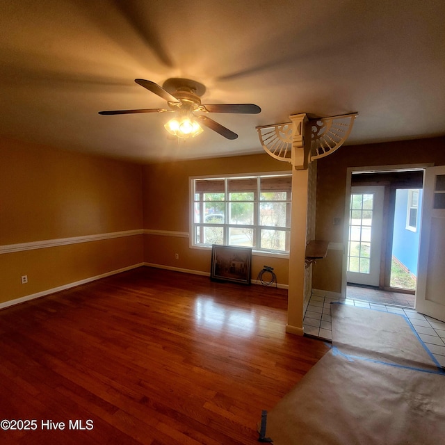 spare room featuring a healthy amount of sunlight, ceiling fan, and wood-type flooring