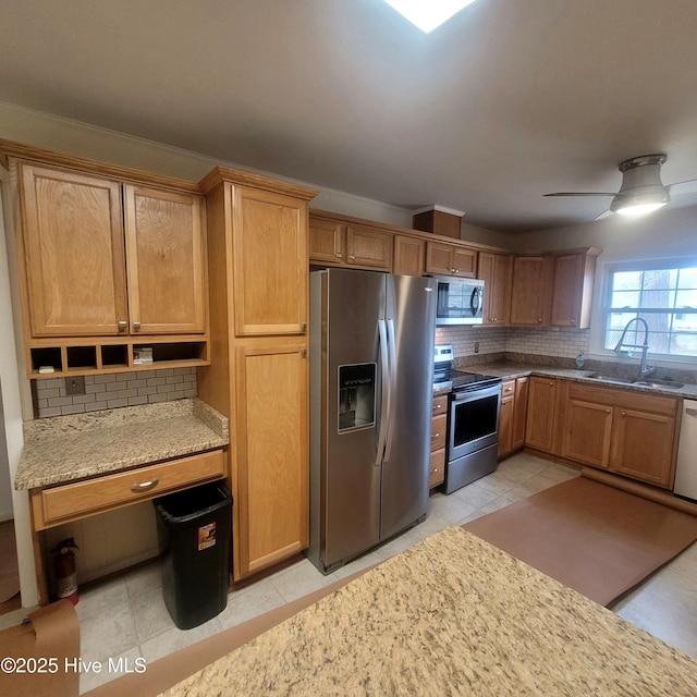 kitchen featuring ceiling fan, appliances with stainless steel finishes, sink, and backsplash