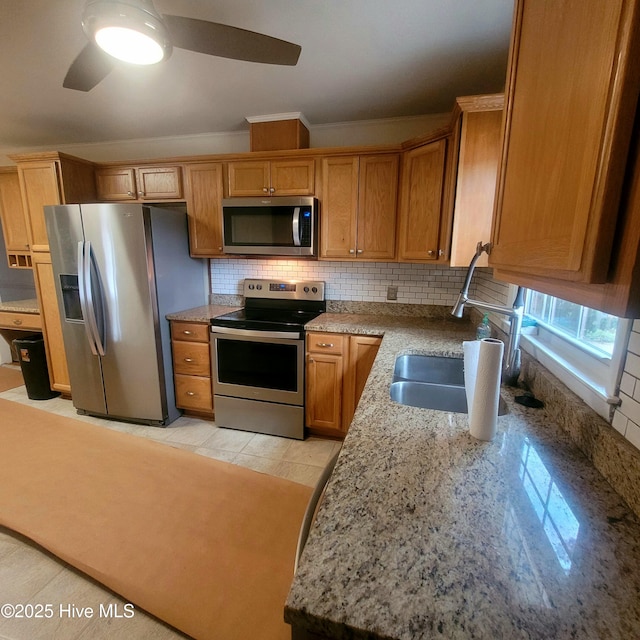 kitchen featuring tasteful backsplash, sink, stainless steel appliances, and light stone countertops