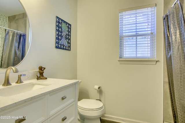 bathroom featuring toilet, vanity, and curtained shower