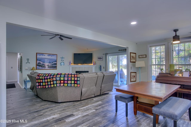 living room with ceiling fan, hardwood / wood-style floors, lofted ceiling, and a healthy amount of sunlight