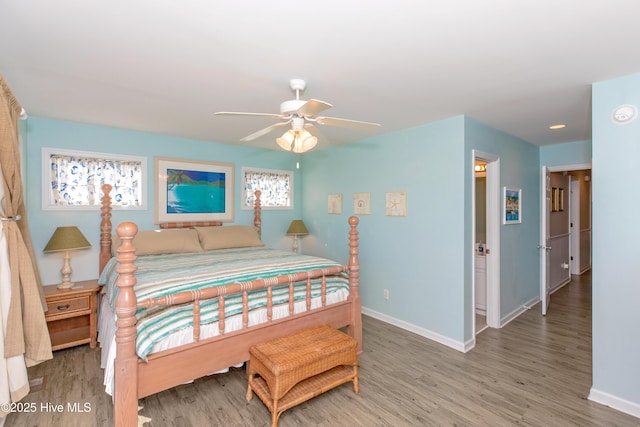 bedroom featuring hardwood / wood-style flooring, ceiling fan, and multiple windows