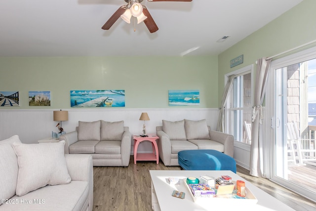 living room featuring ceiling fan, a healthy amount of sunlight, and light wood-type flooring