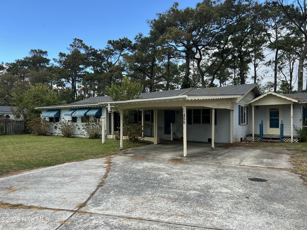 view of front of house with a carport and a front lawn