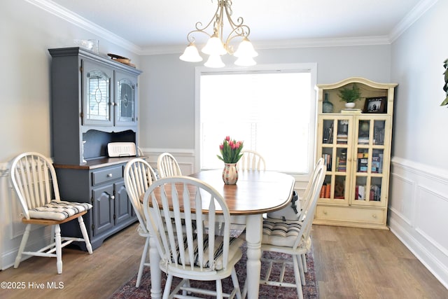 dining area with crown molding, wood-type flooring, and a chandelier