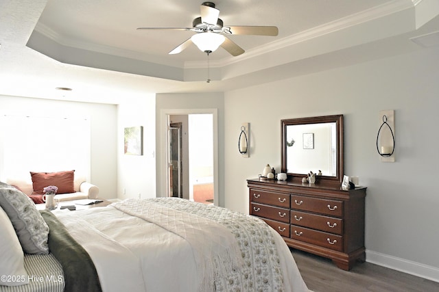 bedroom featuring crown molding, ceiling fan, connected bathroom, and a tray ceiling