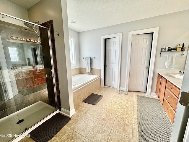 bathroom featuring vanity, independent shower and bath, tile patterned flooring, and a textured ceiling