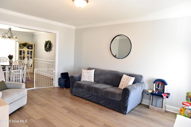 living room with a notable chandelier, crown molding, and hardwood / wood-style floors