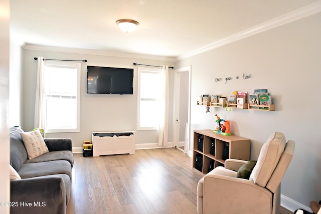 living room featuring crown molding, plenty of natural light, and light hardwood / wood-style floors