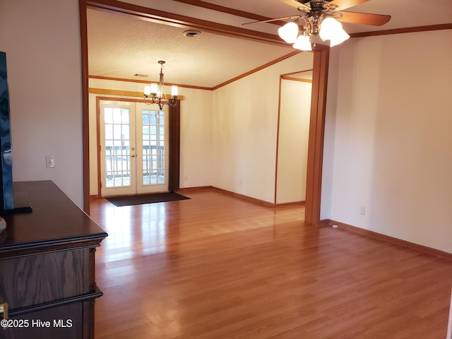 unfurnished living room featuring french doors, light wood-type flooring, ceiling fan with notable chandelier, and ornamental molding