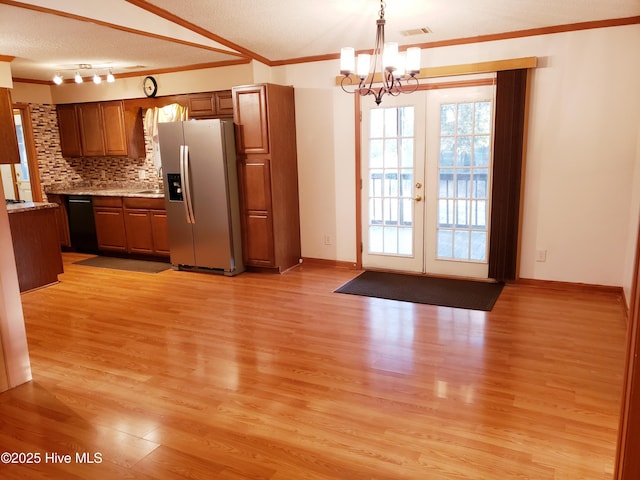 kitchen featuring stainless steel refrigerator with ice dispenser, french doors, tasteful backsplash, a textured ceiling, and light hardwood / wood-style flooring