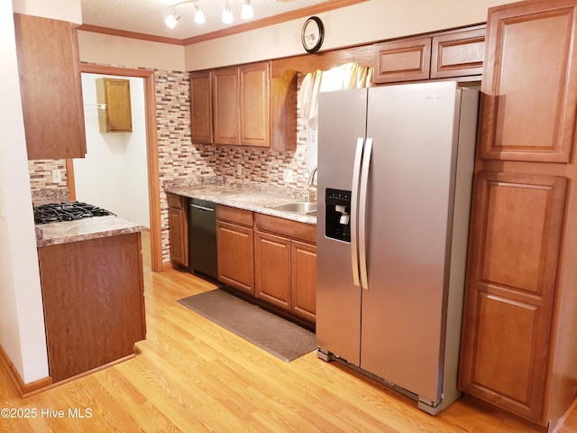 kitchen featuring decorative backsplash, sink, light wood-type flooring, and appliances with stainless steel finishes