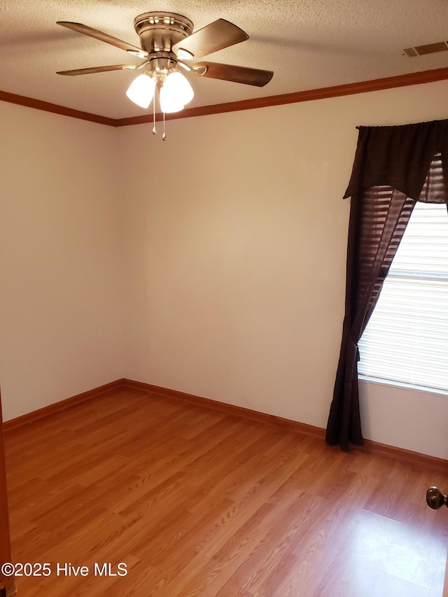 unfurnished room with ceiling fan, ornamental molding, a textured ceiling, and light hardwood / wood-style flooring