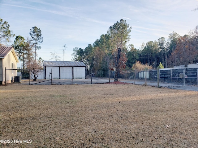 view of yard featuring a garage, an outdoor structure, and central air condition unit