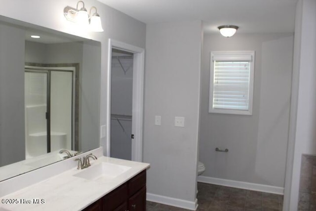 bathroom with toilet, vanity, an inviting chandelier, and an enclosed shower