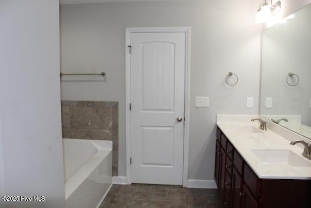 bathroom with tile patterned floors, a tub, and vanity