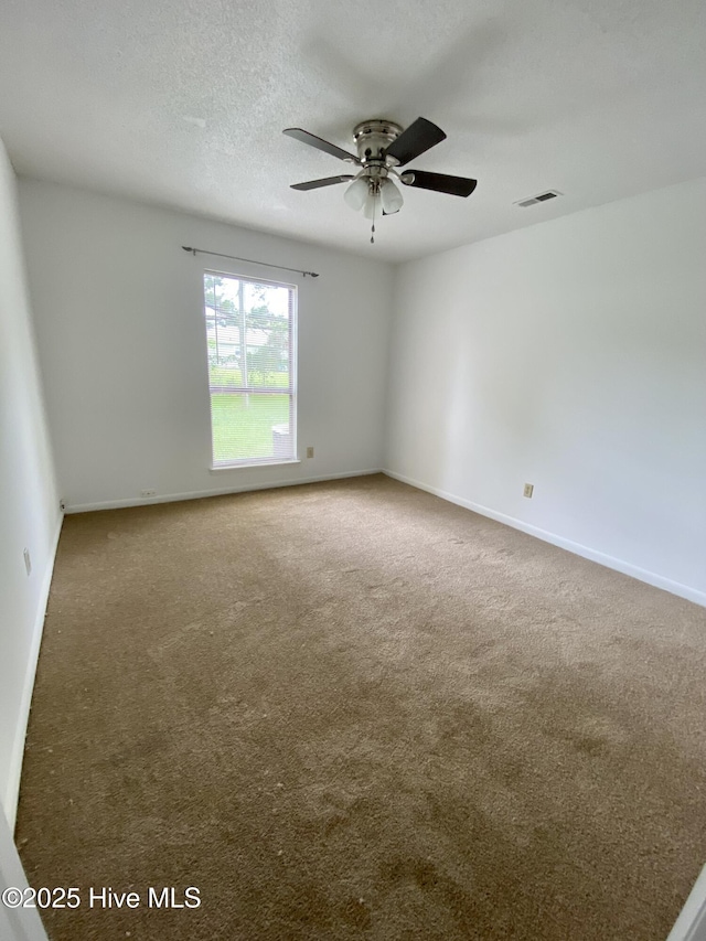 carpeted spare room with a textured ceiling and ceiling fan