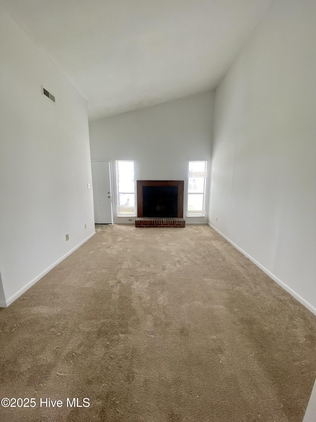 unfurnished living room featuring a fireplace, carpet, and vaulted ceiling