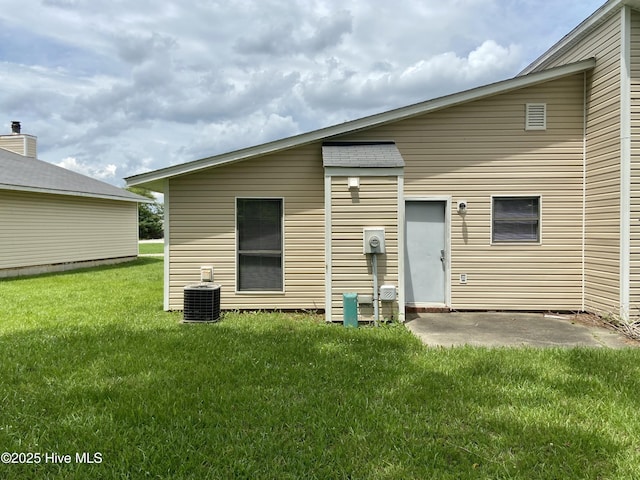 rear view of house featuring central air condition unit, a patio area, and a yard